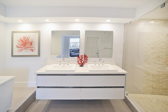 bathroom featuring tiled shower and vanity