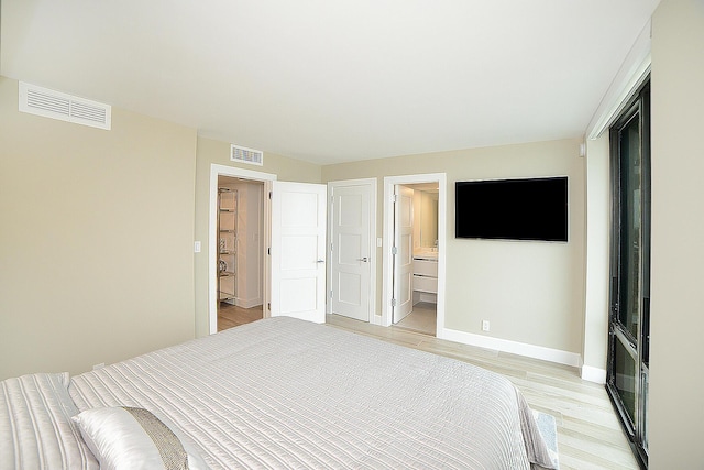 unfurnished bedroom with light wood-type flooring and ensuite bath