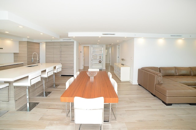 dining room featuring sink and light hardwood / wood-style flooring