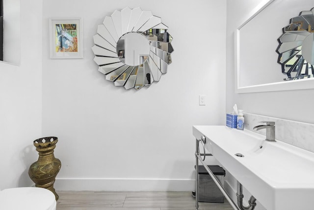 bathroom featuring toilet and baseboards