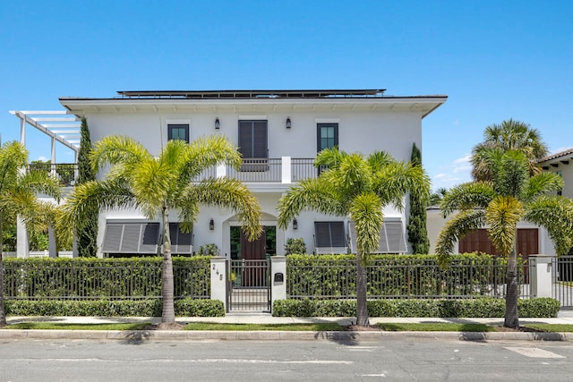 view of front of home featuring solar panels and a balcony