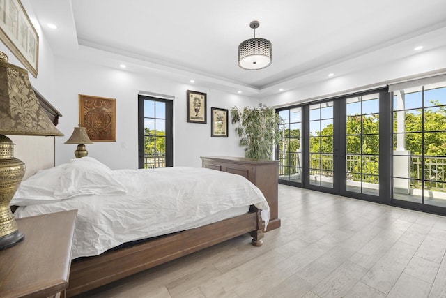 bedroom featuring access to outside, french doors, multiple windows, and wood finished floors