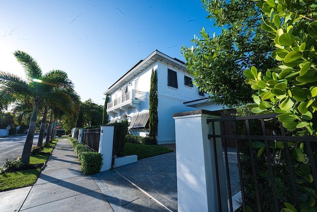 view of home's exterior featuring a fenced front yard, stucco siding, and a gate