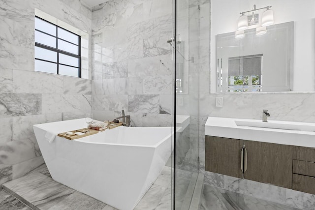 bathroom with marble finish floor, a freestanding bath, vanity, and a marble finish shower