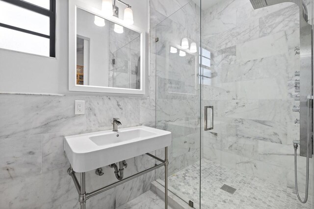 bathroom featuring ceiling fan, a shower with door, vanity, and tile walls