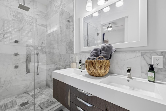 full bathroom featuring double vanity, a marble finish shower, and a sink