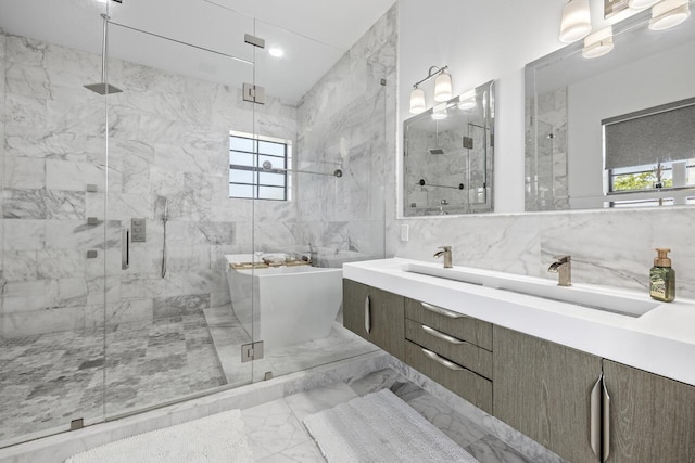 full bath with vanity, a marble finish shower, a soaking tub, tile walls, and marble finish floor