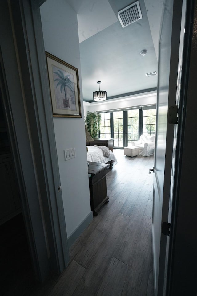 hall with visible vents, dark wood-type flooring, and french doors