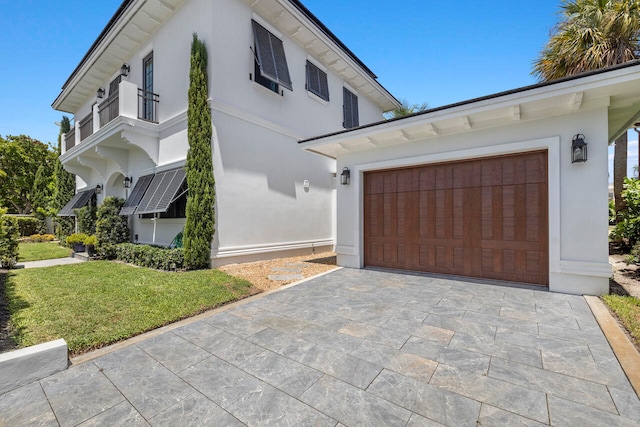 view of front of house with a balcony, a front yard, and a garage