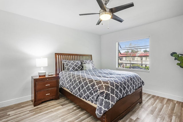 bedroom featuring light wood-type flooring, baseboards, and a ceiling fan