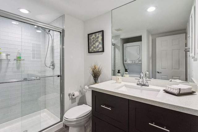 bathroom with stacked washer and clothes dryer, visible vents, toilet, a shower stall, and vanity