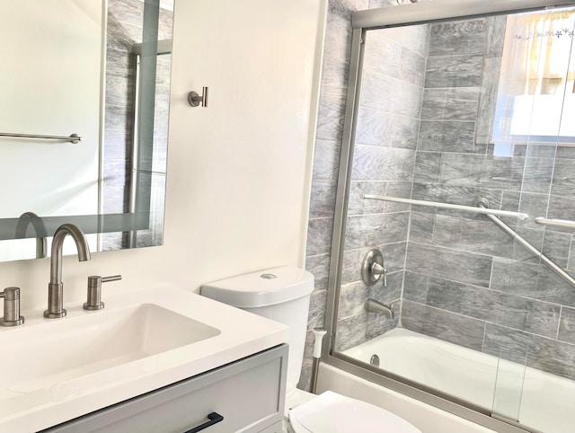 full bathroom with toilet, vanity, and combined bath / shower with glass door