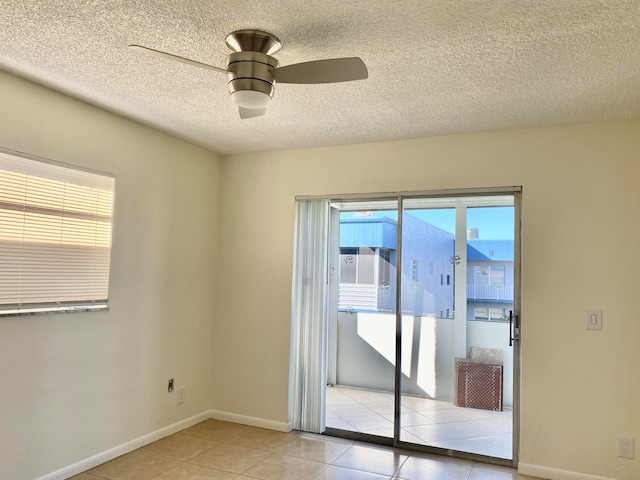 tiled empty room with ceiling fan and a textured ceiling