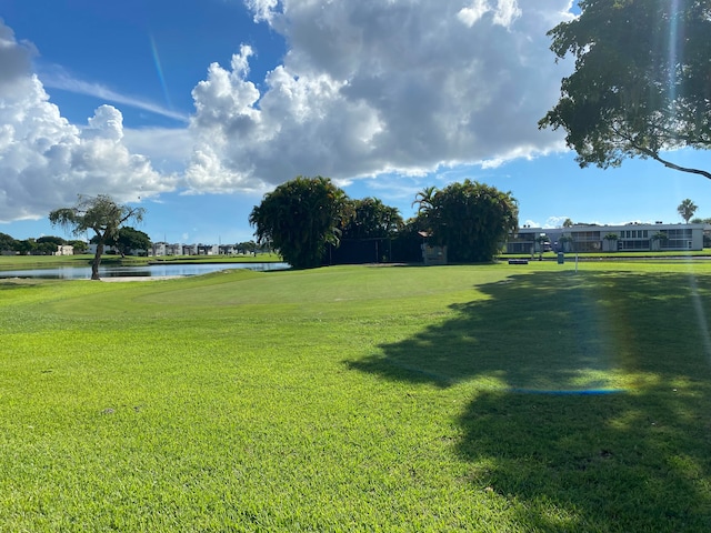 view of property's community featuring a lawn and a water view