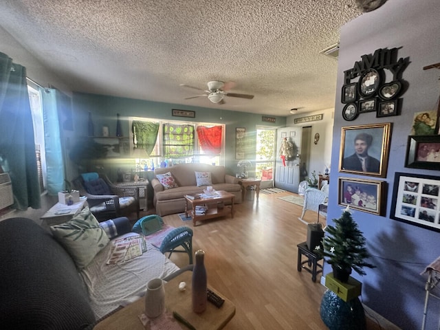 living room featuring ceiling fan, hardwood / wood-style floors, and a textured ceiling