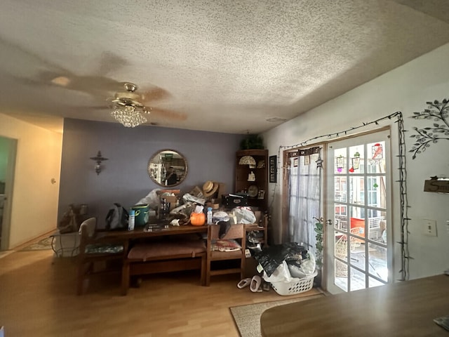 interior space featuring ceiling fan, wood-type flooring, and a textured ceiling