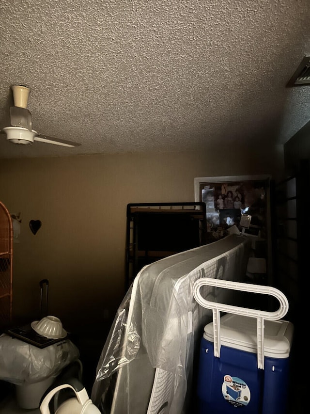 bedroom featuring a textured ceiling and ceiling fan