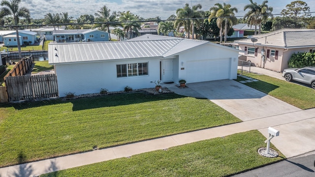 ranch-style house with a garage, driveway, a front lawn, and stucco siding