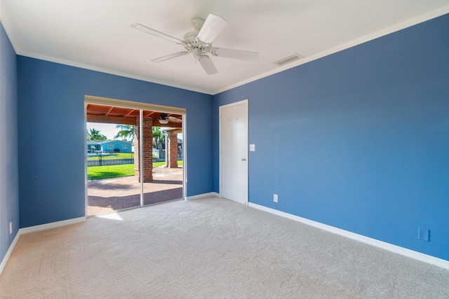 empty room with ceiling fan, light colored carpet, and ornamental molding