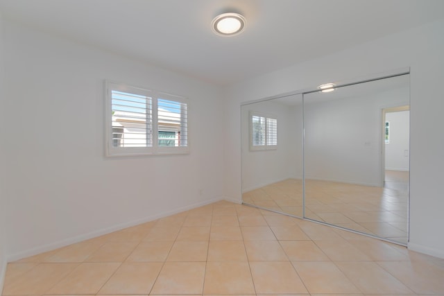 unfurnished bedroom featuring light tile patterned floors and a closet