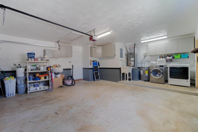 garage with separate washer and dryer, electric panel, and a garage door opener