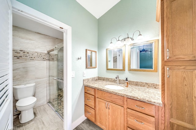 bathroom with vanity, toilet, an enclosed shower, and lofted ceiling