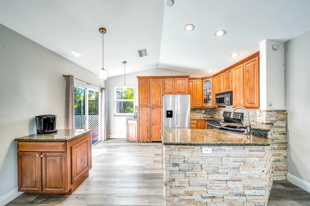 kitchen with tasteful backsplash, kitchen peninsula, dark stone counters, vaulted ceiling, and appliances with stainless steel finishes