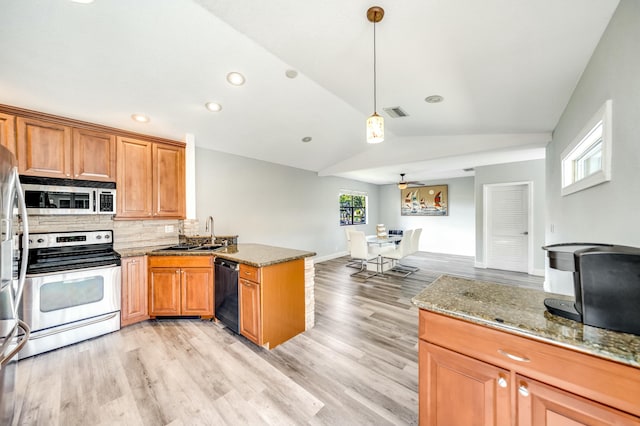 kitchen with ceiling fan, kitchen peninsula, pendant lighting, vaulted ceiling, and appliances with stainless steel finishes