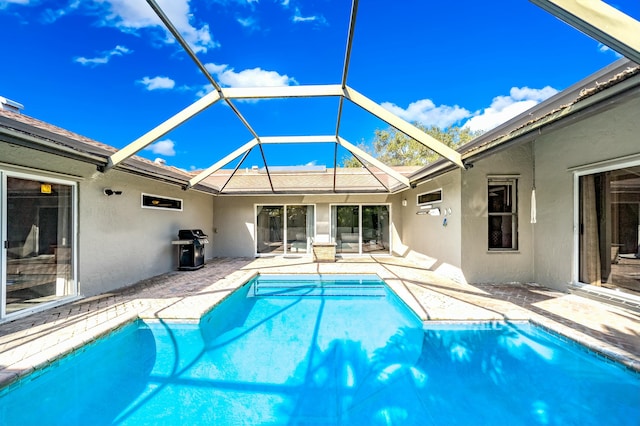 view of pool featuring glass enclosure, area for grilling, and a patio