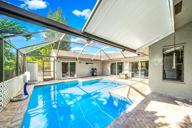 view of swimming pool featuring a lanai, area for grilling, and a patio