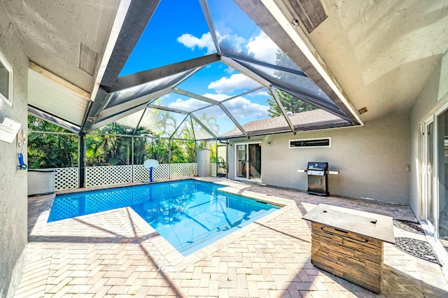 view of pool featuring a grill, glass enclosure, and a patio