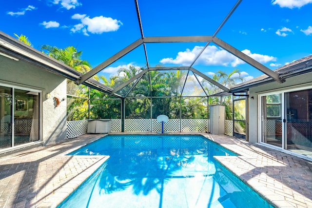 view of pool featuring glass enclosure and a patio