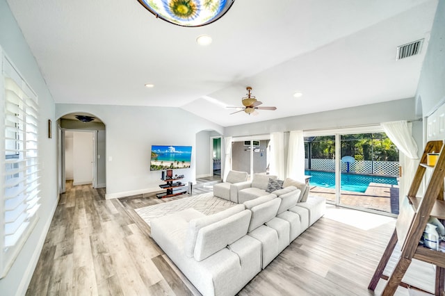 living room featuring ceiling fan, light hardwood / wood-style flooring, and vaulted ceiling