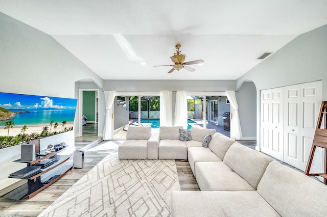 living room with light hardwood / wood-style floors, ceiling fan, and lofted ceiling