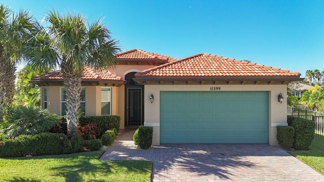 mediterranean / spanish-style home with a front yard and a garage