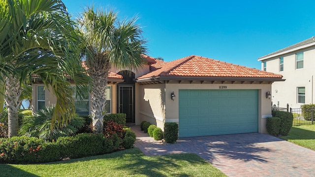 mediterranean / spanish home featuring a front yard and a garage