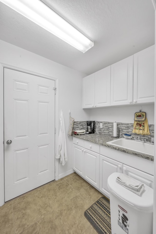 laundry area with a textured ceiling and sink