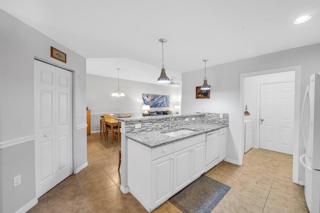 kitchen with light stone counters, white appliances, ceiling fan with notable chandelier, sink, and white cabinetry