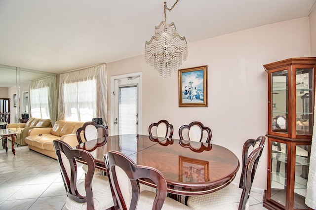 tiled dining room with a chandelier