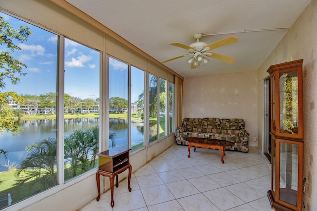 sunroom / solarium with a water view and ceiling fan