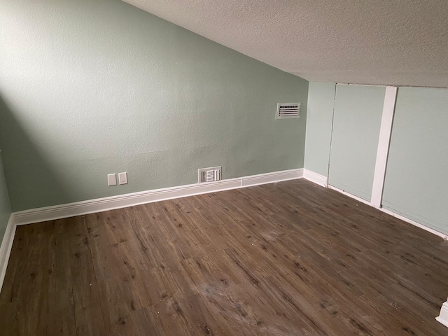 unfurnished room with dark hardwood / wood-style floors and a textured ceiling