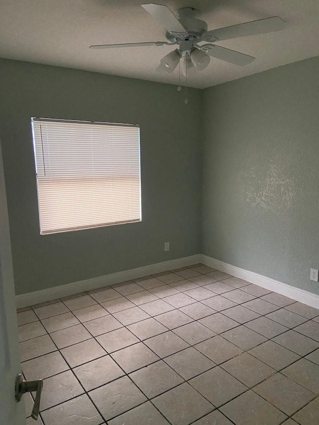 unfurnished room featuring light tile patterned flooring and ceiling fan