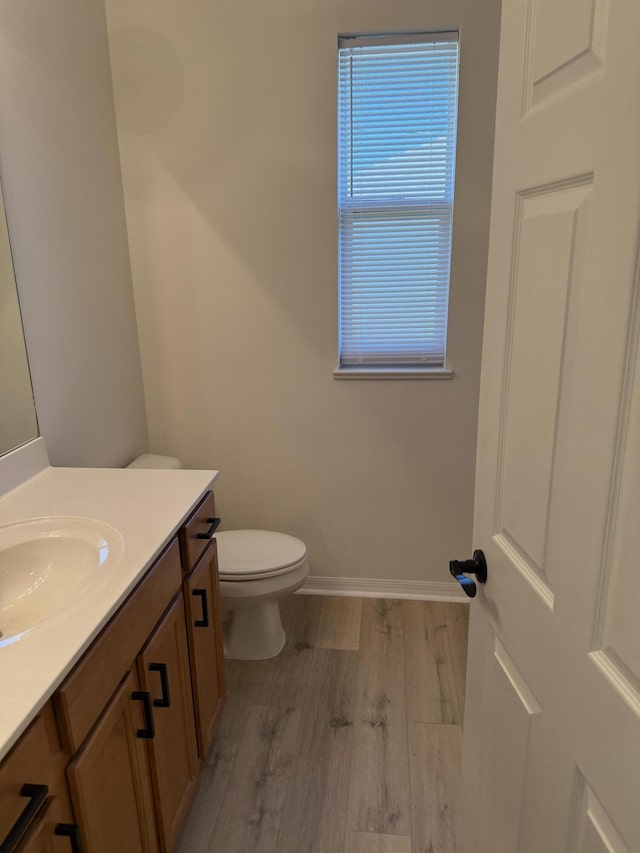 bathroom featuring wood-type flooring, vanity, and toilet