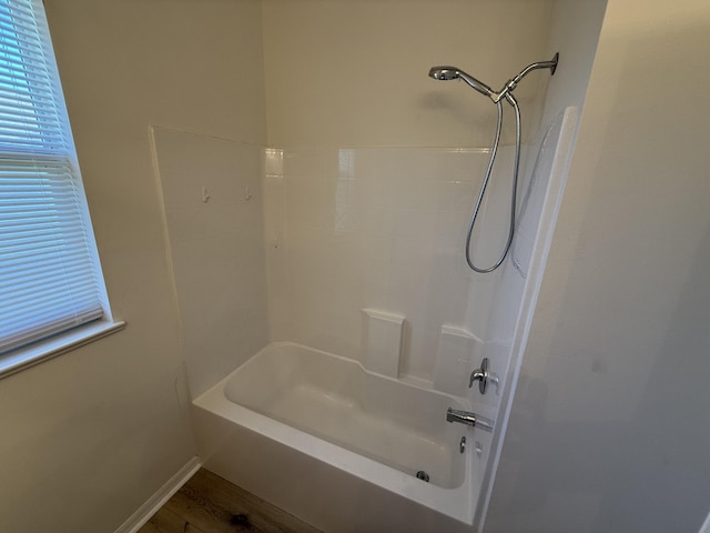 bathroom with wood-type flooring and tub / shower combination