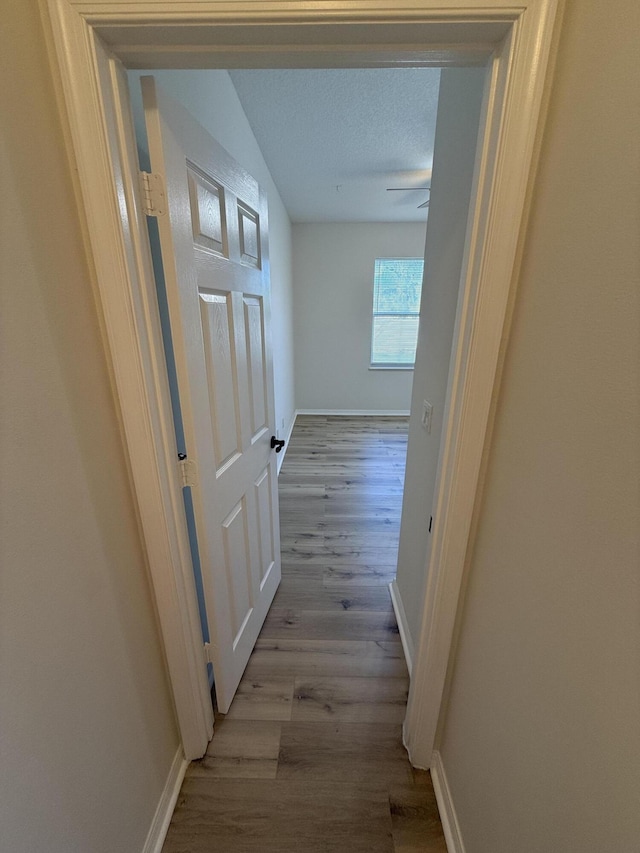 hall featuring a textured ceiling and light wood-type flooring