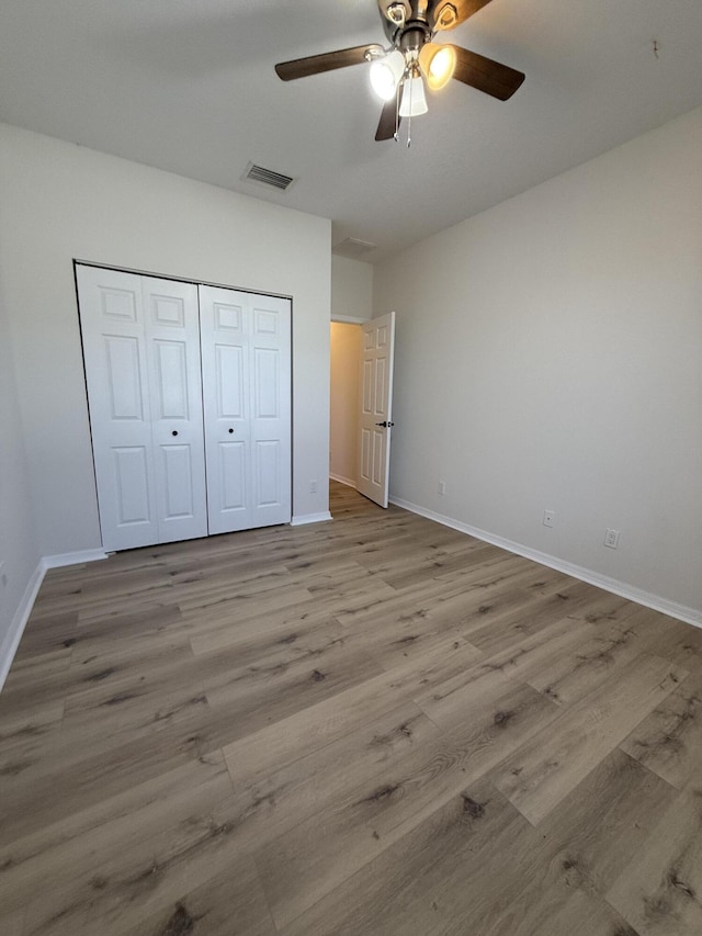 unfurnished bedroom with a closet, ceiling fan, and light hardwood / wood-style flooring