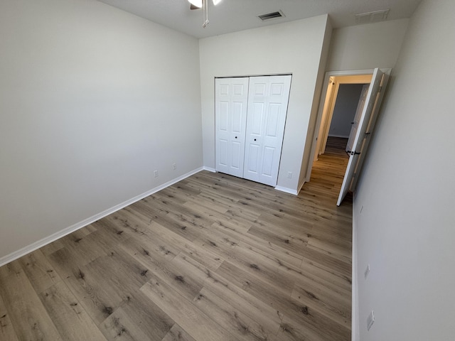 unfurnished bedroom with light wood-type flooring and a closet