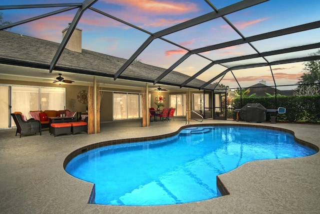 pool at dusk featuring outdoor lounge area, ceiling fan, a patio area, and a lanai