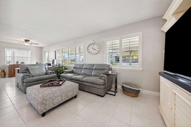 living room featuring ceiling fan, light tile patterned floors, and a textured ceiling