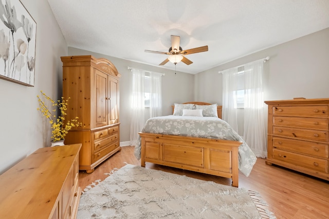 bedroom with ceiling fan and light hardwood / wood-style flooring